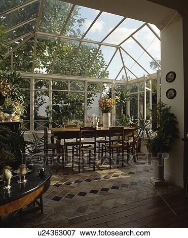 Old wood tables and chairs on terracotta tiled floor in conservatory dining room View Large Photo Image Stock Photo - Old wood tables and chairs on terracotta tiled floor in conservatory dining room. Fotosearch