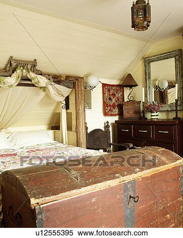 Old wooden chest at the foot of the bed in cream attic bedroom with wooden ceiling View Large Photo Image Stock Photography - Old wooden chest at the foot of the bed in cream attic bedroom with wooden ceiling. Fotosearch