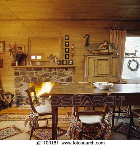 Old wooden table and chairs in dining room with stone fireplace and wood walls View Large Photo Image Stock Image - Old wooden table and chairs in dining room with stone fireplace and wood walls. Fotosearch