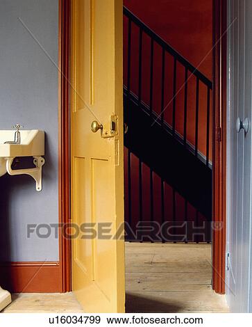 Stock Photo - Open yellow door with view of landing. Fotosearch