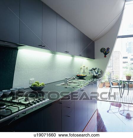Openplan modern kitchen leading onto covered decked area View Large Photo Image Stock Image - Openplan modern kitchen leading onto covered decked area. Fotosearch