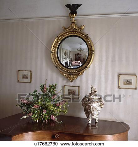 Ornate gilt antique convex mirror on wall of living room with striped wallpaper View Large Photo Image Stock Image - Ornate gilt antique convex mirror on wall of living room with striped wallpaper. Fotosearch