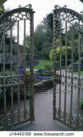 Stock Photo - Ornate metal gates and view of large country garden. Fotosearch