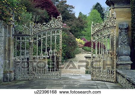 Ornate wrought iron gates to large country garden in summer View Large Photo Image Stock Photo - Ornate wrought iron gates to large country garden in summer. Fotosearch