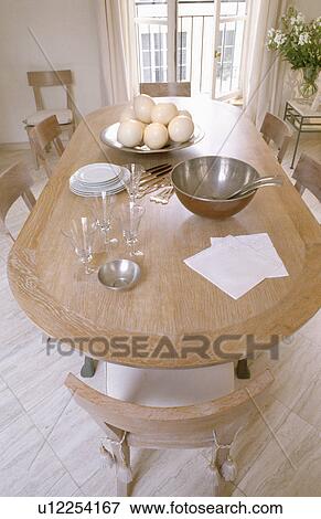 Ostrich eggs and metal bowls on pale wood oval table in French apartment View Large Photo Image Stock Photo - Ostrich eggs and metal bowls on pale wood oval table in French apartment . Fotosearch