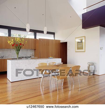 Pâle Bois Et Métal Chaises Et Table Dans Moderne Blanc Cuisine à Plancher Bois Et élevé Plafond Banque Dimage