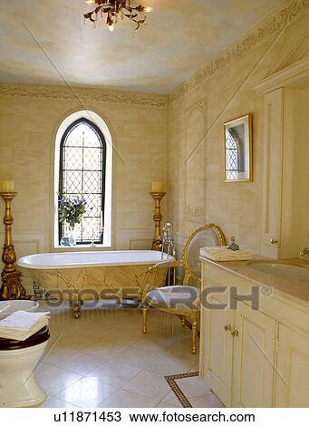 Paint effect marbled clawfoot bath and stone walls in traditional bathroom with antique chair and tiled floor View Large Photo Image Stock Image - Paint effect marbled clawfoot bath and stone walls in traditional bathroom with antique chair and tiled floor. Fotosearch