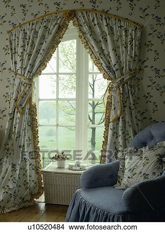 Pale blue armchair in front of French windows with yellow-edged floral curtains and matching wallpaper View Large Photo Image Picture - Pale blue armchair in front of French windows with yellow-edged floral curtains and matching wallpaper. Fotosearch