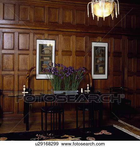 Panelled hall dining room with blue iris in metal pot on narrow table below pictures View Large Photo Image Stock Photo - Panelled hall dining room with blue iris in metal pot on narrow table below pictures. Fotosearch