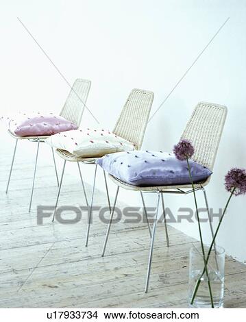 Pastel silk cushions on wicker chairs with metal legs on wooden flooring View Large Photo Image Picture - Pastel silk cushions on wicker chairs with metal legs on wooden flooring. Fotosearch
