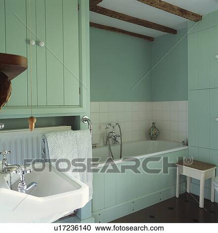 Stock Image - Pastel turquoise cottage bathroom with recessed bath. Fotosearch