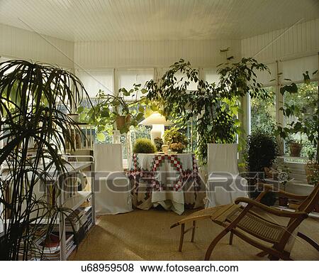 Stock Photo - Patchwork cloth on table in living room with green houseplants. Fotosearch