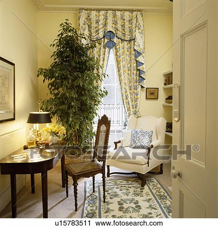 Patterned swagged curtains in traditional living room View Large Photo Image Stock Image - Patterned swagged curtains in traditional living room. Fotosearch