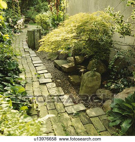 Paved path and large stones in town garden View Large Photo Image Stock Photo - Paved path and large stones in town garden. Fotosearch