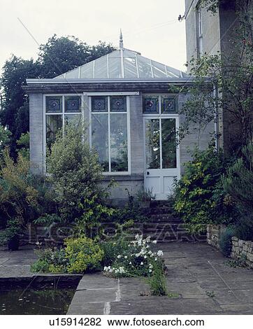Paved terrace and traditional Victorian conservatory with stained glass details on the windows View Large Photo Image Stock Image - Paved terrace and traditional Victorian conservatory with stained glass details on the windows . Fotosearch