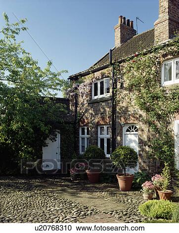 Pebble and stone paving on courtyard in front of traditional country cottage View Large Photo Image Stock Image - Pebble and stone paving on courtyard in front of traditional country cottage. Fotosearch