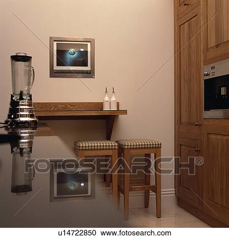 Picture above single wooden shelf and upholstered stools in modern kitchen with electric blender on glass counter View Large Photo Image Stock Image - Picture above single wooden shelf and upholstered stools in modern kitchen with electric blender on glass counter. Fotosearch