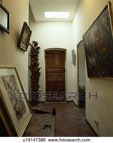 Pictures and wooden sculpture in narrow white hall View Large Photo Image Stock Photograph - Pictures and wooden sculpture in narrow white hall. Fotosearch