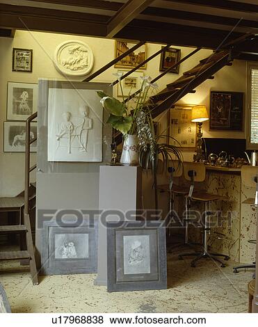 Stock Photo - Pictures on floor beside staircase in neutral kitchen . Fotosearch