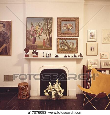 Pictures On Wall Above Fireplace In Living Room With Yellow