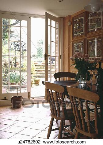 Pine furniture in dining room extension with terracotta tiled floor and French doors open to patio gvarden View Large Photo Image Stock Image - Pine furniture in dining room extension with terracotta tiled floor and French doors open to patio gvarden. Fotosearch