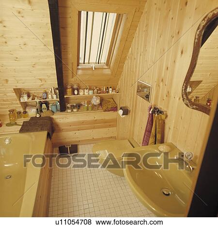 Stock Photo - Pine panelled attic&#13; &#10; bathroom with yellow bath and basin. Fotosearch