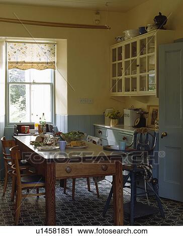 Pine table and chairs in cream and blue traditional kitchen with patterned flooring View Large Photo Image Stock Image - Pine table and chairs in cream and blue traditional kitchen with patterned flooring. Fotosearch