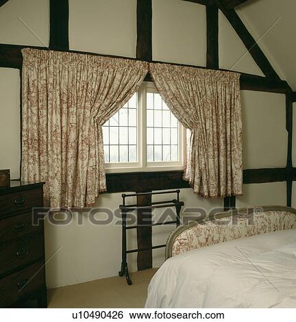 Stock Photograph - Pink toile-de-Jouy curtains in country bedroom . Fotosearch
