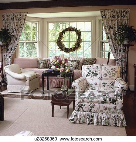 Pink+green floral loosecover on armchair in traditional country living room View Large Photo Image Stock Photo - Pink+green floral loosecover on armchair in traditional country living room. Fotosearch