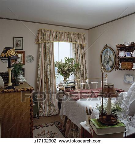 Pink+green glazed cotton curtains in cottage bedroom with bamboo chest-of-drawers and white brass bed View Large Photo Image Stock Image - Pink+green glazed cotton curtains in cottage bedroom with bamboo chest-of-drawers and white brass bed. Fotosearch