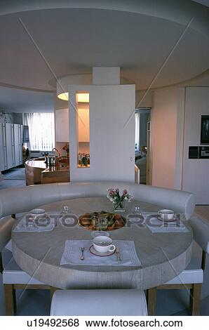 Place settings on circular stone table in openplan eighties dining room with circular false ceiling an View Large Photo Image Stock Photo - Place settings on circular stone table in openplan eighties dining room with circular false ceiling an. Fotosearch