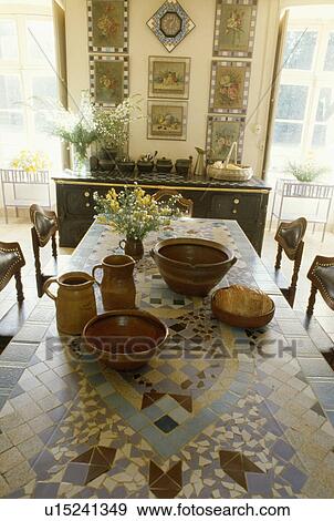 Pottery jugs and bowls on mosaic table in traditional dining room View Large Photo Image Stock Photo - Pottery jugs and bowls on mosaic table in traditional dining room. Fotosearch