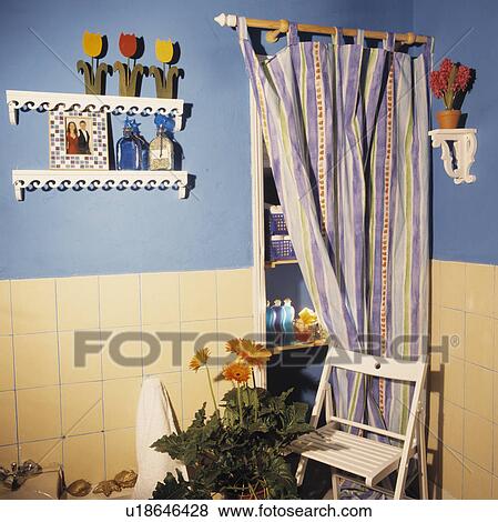 Purple striped curtain concealing alcove shelving in pastel blue bathroom with Jali shelves and cream wall tiles View Large Photo Image Stock Photo - Purple striped curtain concealing alcove shelving in pastel blue bathroom with Jali shelves and cream wall tiles. Fotosearch