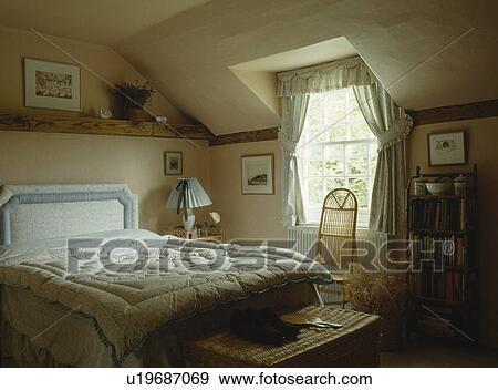 Quilt On Upholstered Bed In Attic Bedroom With Wicker Chair Attic Bedroom With Wicker Chair