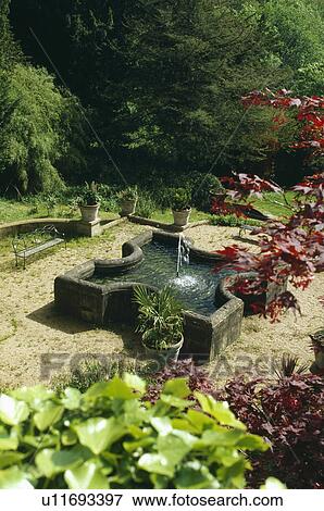 Raised pond and fountain in country garden View Large Photo Image Stock Photo - Raised pond and fountain in country garden. Fotosearch