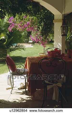 Red cloth on table with metal chairs on Mediterranean veranda View Large Photo Image Picture - Red cloth on table with metal chairs on Mediterranean veranda. Fotosearch