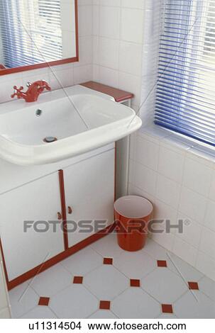 Red tap on white basin in sixties bathroom with red wastebin and red and white tiled floor View Large Photo Image Picture - Red tap on white basin in sixties bathroom with red wastebin and red and white tiled floor. Fotosearch