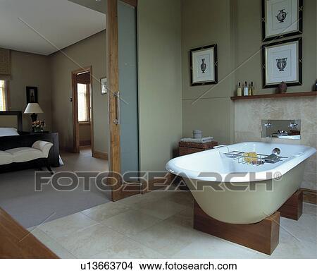 Rolltop bath on wooden stand in modern ensuite bathroom with sliding door to bedroom View Large Photo Image Picture - Rolltop bath on wooden stand in modern ensuite bathroom with sliding door to bedroom. Fotosearch