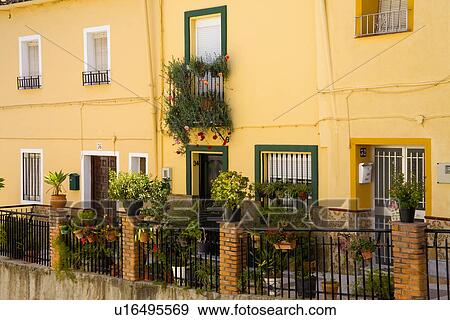 Stock Photo - Row of traditional Spanish houses painted yellow. Fotosearch