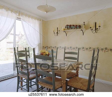 Rush seated green ladderback chairs in dining room with paint effect ragging walls with stencil border View Large Photo Image Stock Image - Rush seated green ladderback chairs in dining room with paint effect ragging walls with stencil border. Fotosearch