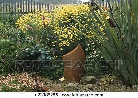 Stock Photography - Sculpture in flowering borders in country garden in summer. Fotosearch