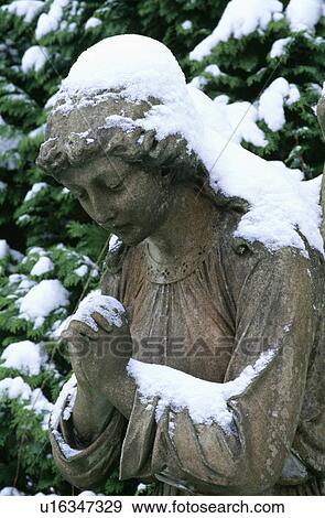 Stock Photo - Sculpture in snow in country garden in winter. Fotosearch