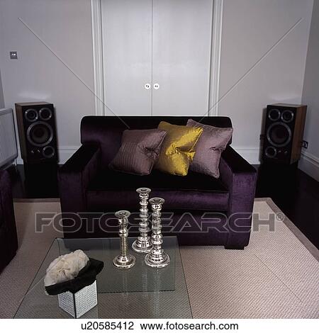 Silver candlesticks on glass table in front of purple sofa with silk cushions in modern living room View Large Photo Image Stock Image - Silver candlesticks on glass table in front of purple sofa with silk cushions in modern living room. Fotosearch