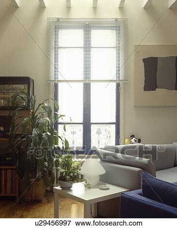 Slatted blind on window in modern living room View Large Photo Image Stock Photo - Slatted blind on window in modern living room. Fotosearch