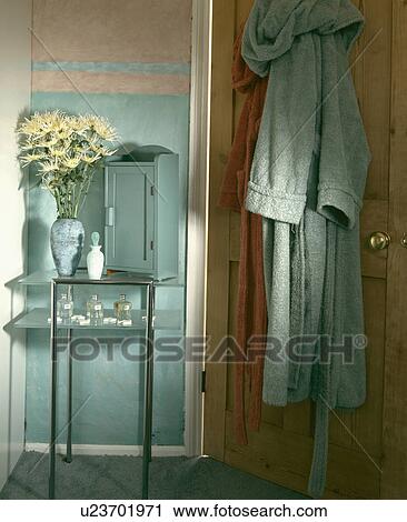 Small pastel turquoise cupboard on glass table beside bathrobes on door in bathroom View Large Photo Image Stock Image - Small pastel turquoise cupboard on glass table beside bathrobes on door in bathroom. Fotosearch