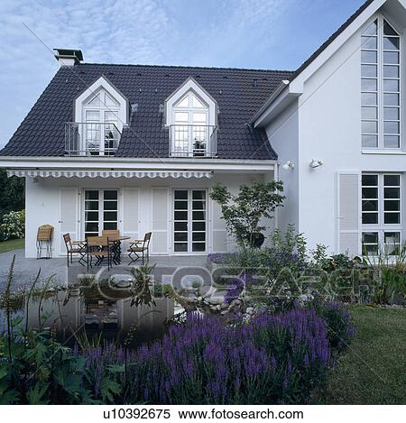 Small Pond In Garden In Front Of Traditional White German House