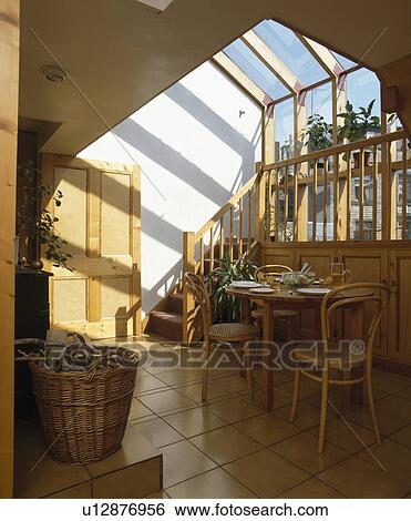 Small wooden table and bentwood chairs in dining room extension with tiled floor View Large Photo Image Stock Photograph - Small wooden table and bentwood chairs in dining room extension with tiled floor. Fotosearch