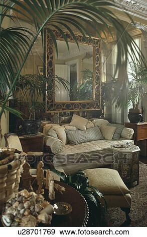 Sofa below mirror in traditional living room with potted palms View Large Photo Image Stock Photo - Sofa below mirror in traditional living room with potted palms. Fotosearch