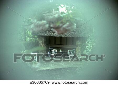 Stock Photo - Soft focus view of directors chairs in open thatched summerhouse. Fotosearch