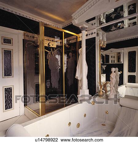 Spa bath below neo-classical pediment in black+white bathroom with glass shower cabinet View Large Photo Image Stock Image - Spa bath below neo-classical pediment in black+white bathroom with glass shower cabinet. Fotosearch